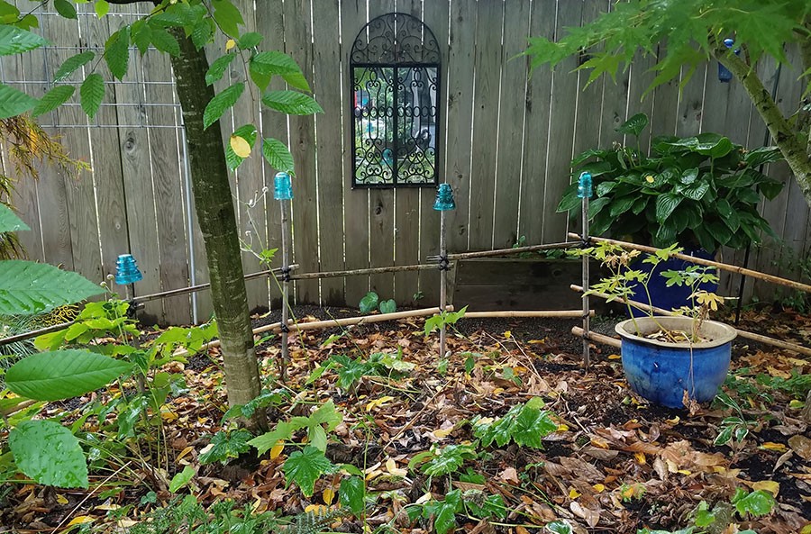 Back mound with glass electrical insulators on bamboo posts and second-hand store mirror